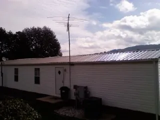 New metal roof on a single wide mobile home with a TV antenna in Spencerville