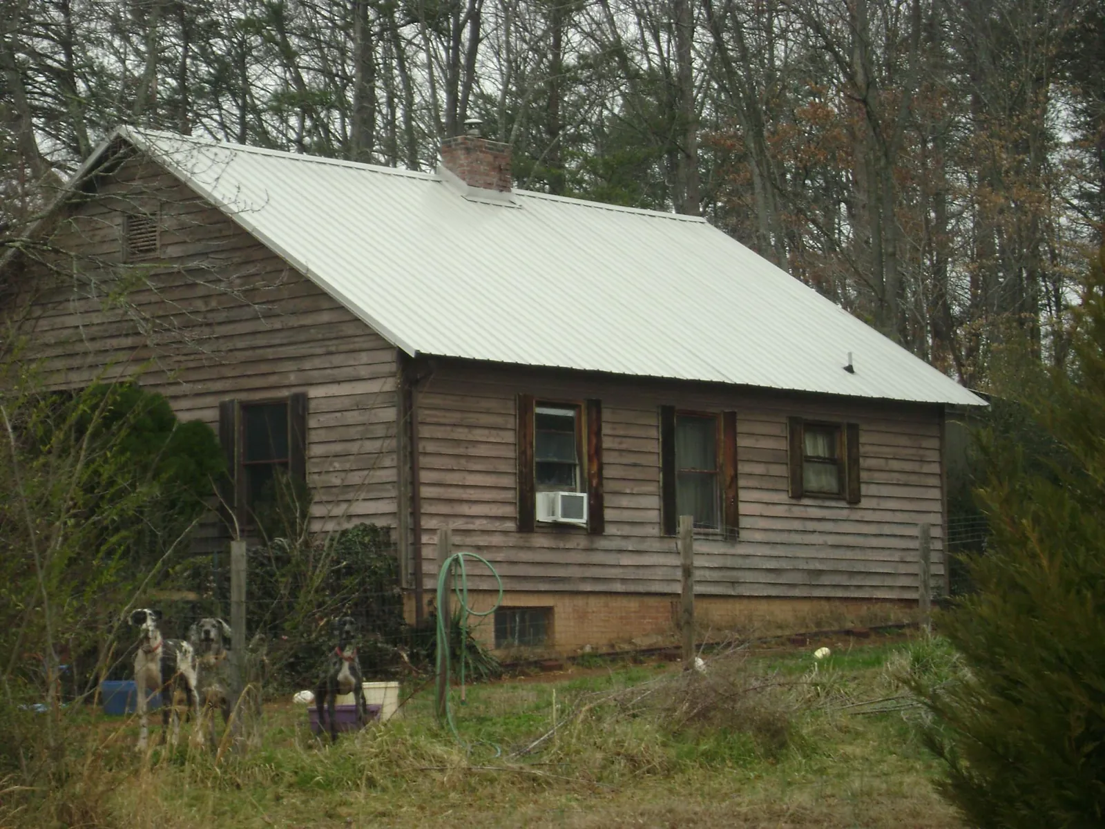 White metal roof on an old wood sided farmhouse, from a Metal Roof Installation job in Spencerville